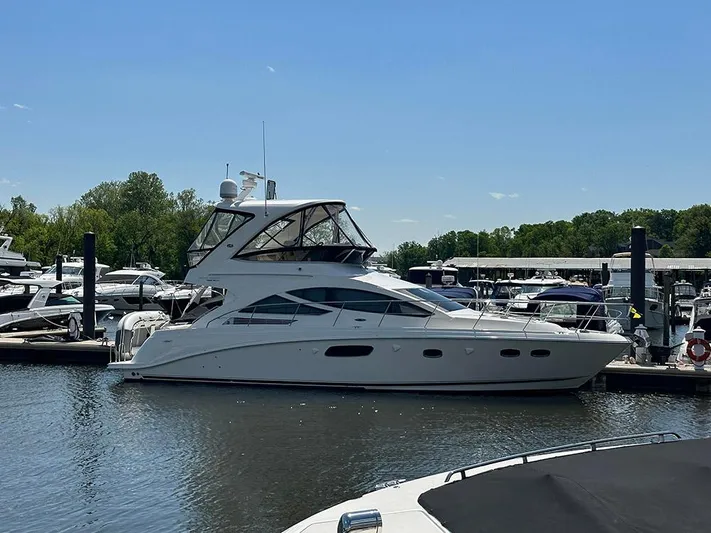  Yacht Photos Pics 2013 Sea Ray 450 Sedan Bridge yacht docked at a marina on a sunny day.