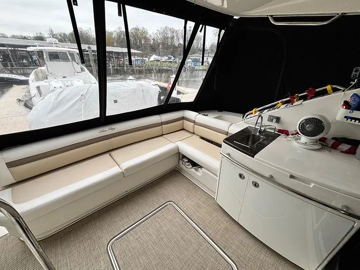  Yacht Photos Pics 2013 Sea Ray 450 Sedan Bridge interior with seating and kitchenette, docked at marina.