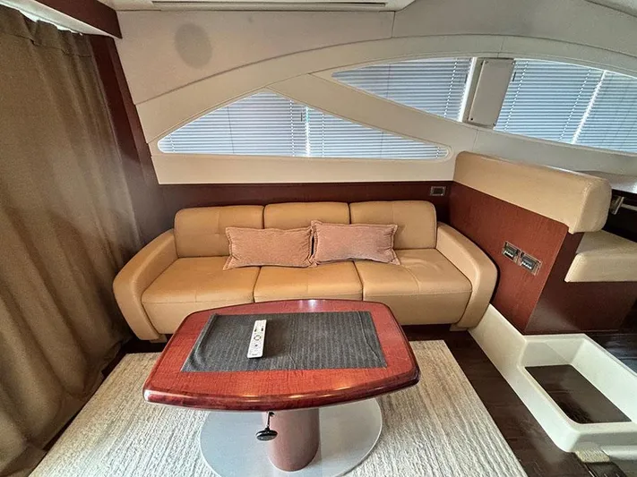  Yacht Photos Pics Luxurious interior of 2013 Sea Ray 450 Sedan Bridge yacht with beige sofa and wooden table.