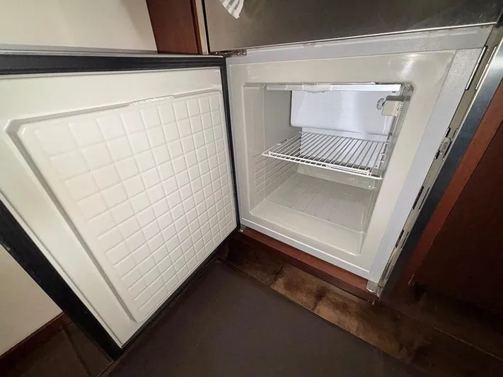  Yacht Photos Pics Open refrigerator inside 2013 Sea Ray 450 Sedan Bridge yacht, showcasing interior storage space.