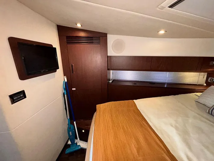 Yacht Photos Pics Interior of 2013 Sea Ray 450 Sedan Bridge with bed, TV, and wooden cabinetry.