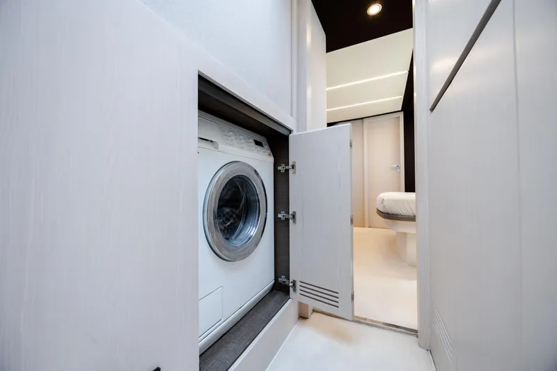  Yacht Photos Pics Laundry area in 2019 Azimut 66 Flybridge yacht, featuring a built-in washing machine.