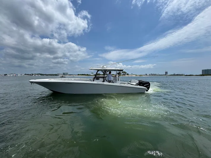  Yacht Photos Pics 2021 Fountain 38TE boat cruising on open water under a partly cloudy sky.