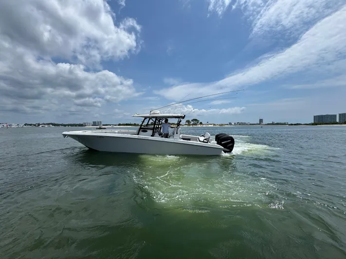 Yacht Photos Pics 2021 Fountain 38TE boat cruising on open water under a partly cloudy sky.