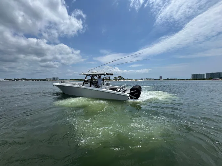  Yacht Photos Pics 2021 Fountain 38TE boat cruising on a sunny day with cityscape in background.