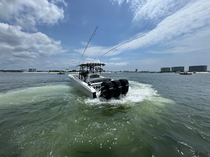  Yacht Photos Pics 2021 Fountain 38TE boat cruising on open water under a partly cloudy sky.