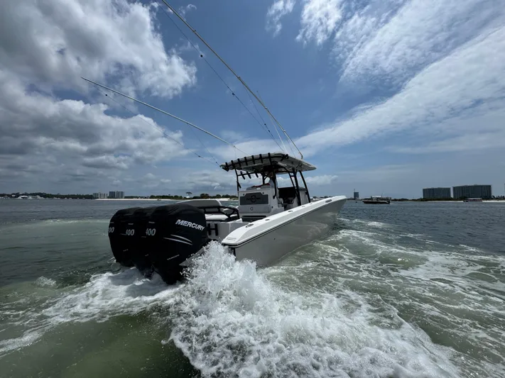  Yacht Photos Pics 2021 Fountain 38TE boat cruising on water with three Mercury engines.