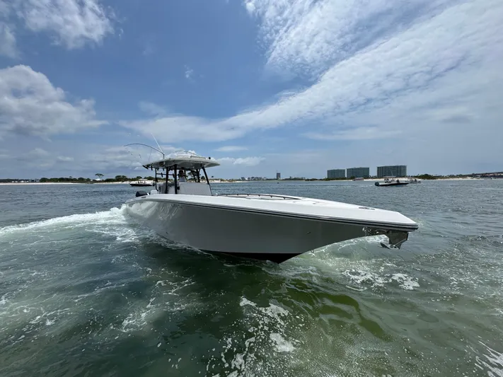  Yacht Photos Pics 2021 Fountain 38TE boat cruising on open water under a partly cloudy sky.