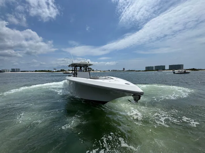  Yacht Photos Pics 2021 Fountain 38TE boat cruising on open water under a partly cloudy sky.