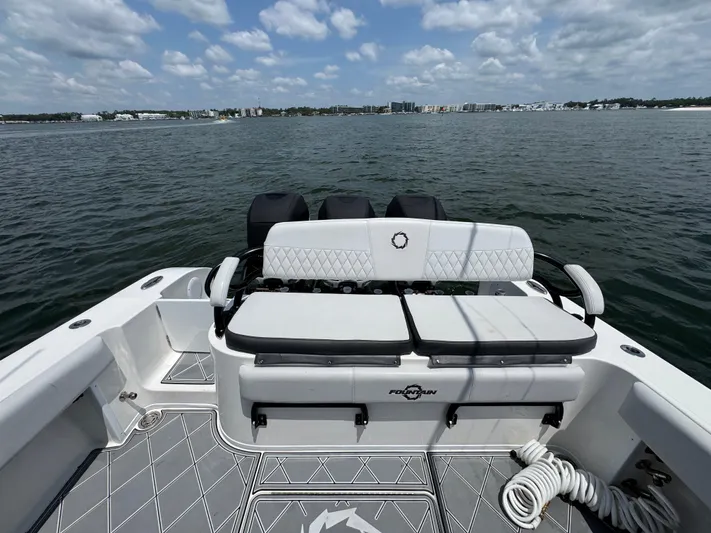  Yacht Photos Pics 2021 Fountain 38TE boat with seating, on a calm water body under a partly cloudy sky.