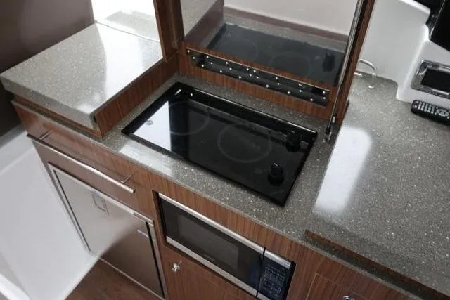  Yacht Photos Pics Modern kitchen area in 2021 Four Winns V355 Coupe yacht with stove and microwave.
