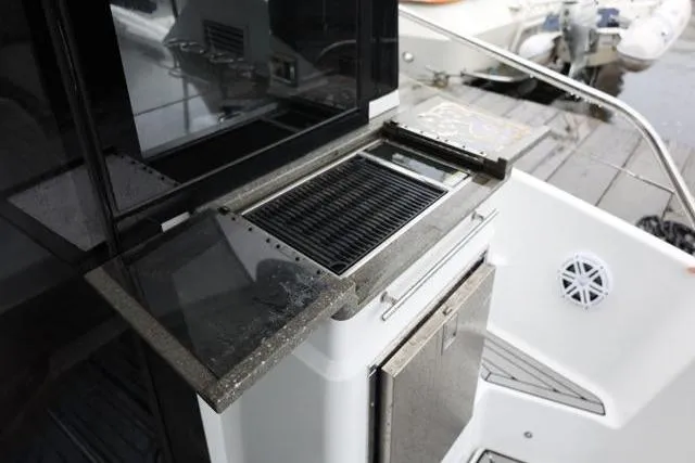  Yacht Photos Pics Outdoor kitchen area on 2021 Four Winns V355 Coupe boat, featuring a grill and storage.