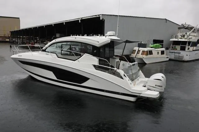  Yacht Photos Pics 2021 Four Winns V355 Coupe boat docked in a marina on a rainy day.