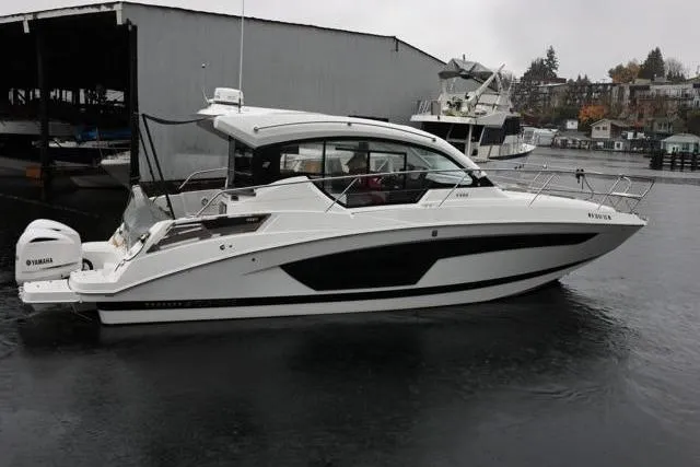  Yacht Photos Pics 2021 Four Winns V355 Coupe boat docked in a marina on a cloudy day.