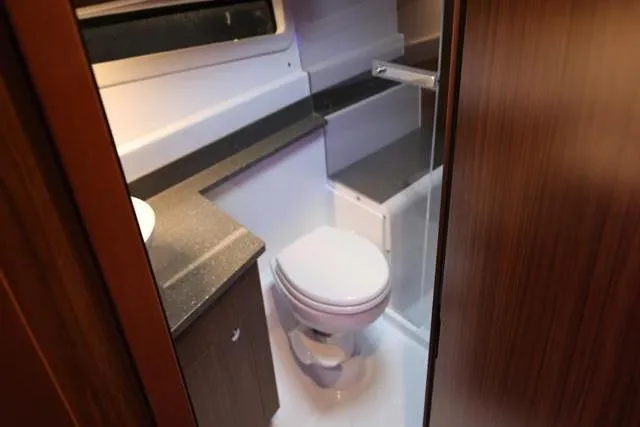  Yacht Photos Pics 2021 Four Winns V355 Coupe bathroom interior with modern fixtures and wood accents.