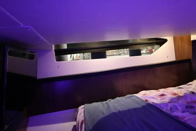  Yacht Photos Pics 2021 Four Winns V355 Coupe cabin interior with cozy bedding and ambient lighting.