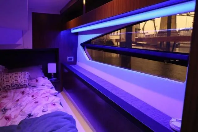  Yacht Photos Pics Interior of 2021 Four Winns V355 Coupe with ambient blue lighting and waterfront view.
