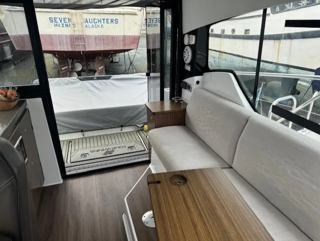  Yacht Photos Pics Interior of 2021 Four Winns Vista 355 Coupe, featuring a sleek seating area and wooden table.