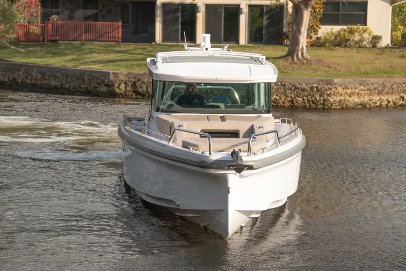  Yacht Photos Pics 2024 Axopar 37XC CROSS CABIN boat cruising on a calm waterway.