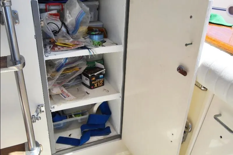  Yacht Photos Pics Open storage cabinet on 1988 Ocean Yachts 38 Super Sport, containing various boating supplies.