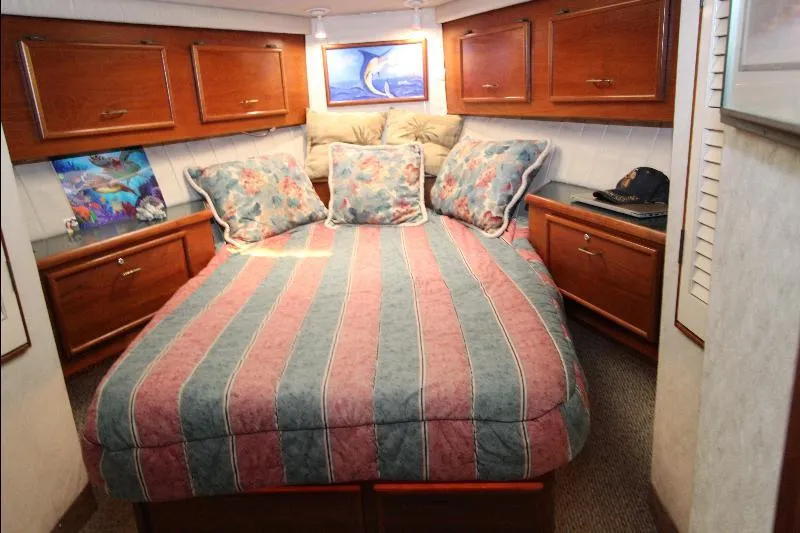  Yacht Photos Pics Cozy bedroom in 1988 Ocean Yachts 38 Super Sport with striped bedding and wooden cabinets.