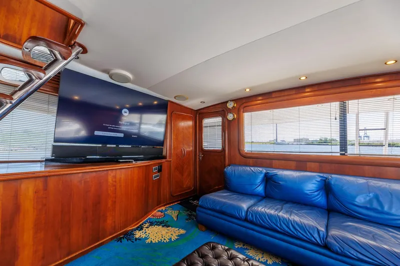 Stress Relief Yacht Photos Pics Luxurious 2003 Tiffany Enclosed Bridge Sport Fish yacht interior with blue sofa and large TV.
