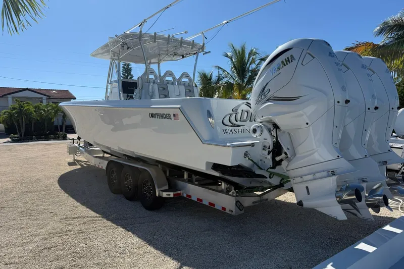 Dig It Yacht Photos Pics 2022 Contender 39 ST boat with triple Yamaha engines on a trailer, sunny day.