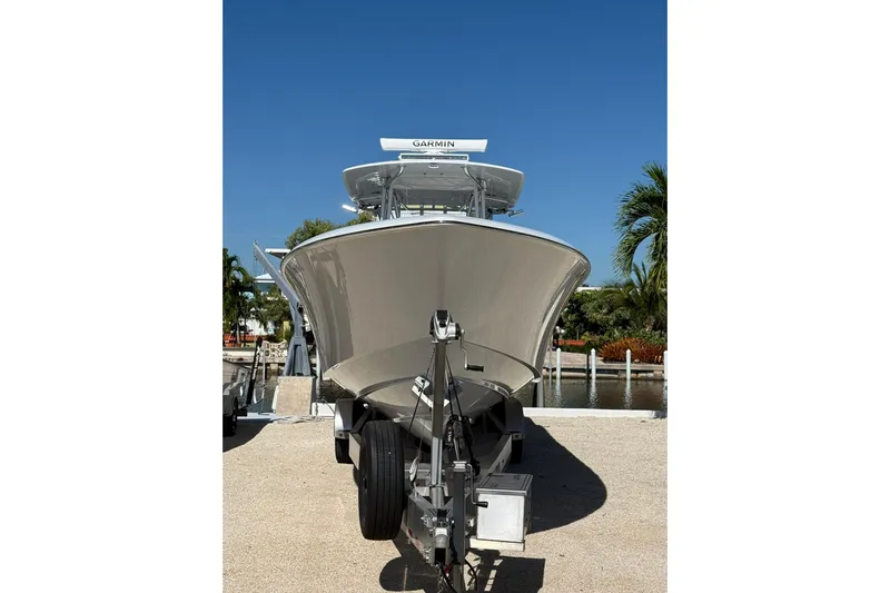 Dig It Yacht Photos Pics 2022 Contender 39 ST boat on trailer, parked near waterfront under clear blue sky.