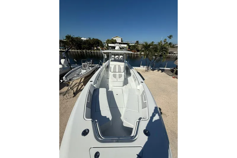 Dig It Yacht Photos Pics 2022 Contender 39 ST boat docked near a waterfront, clear sky background.