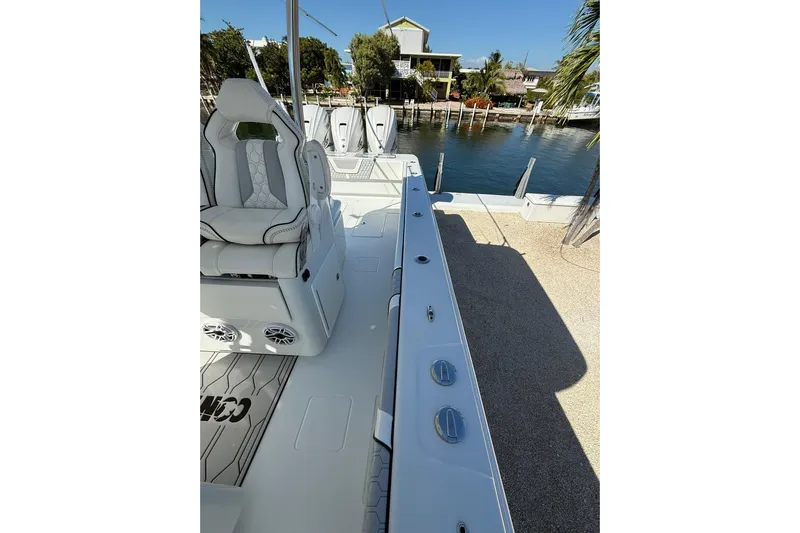 Dig It Yacht Photos Pics 2022 Contender 39 ST boat interior with seating, docked by waterfront homes.