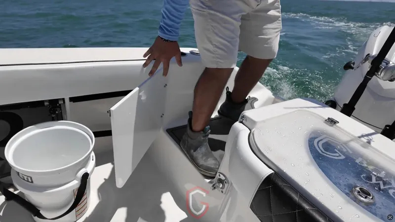  Yacht Photos Pics Person on 2023 CG Boat Works 35 M-Series, accessing storage compartment on deck.