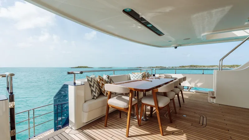Midnight Saga Yacht Photos Pics Luxurious 2023 Moonen 110 yacht deck with elegant dining area overlooking serene ocean views.