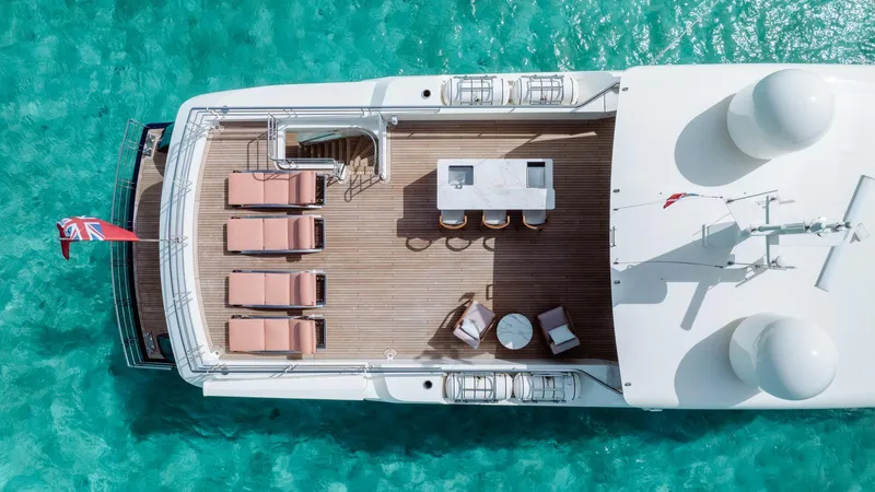 Midnight Saga Yacht Photos Pics Aerial view of 2023 Moonen 110 yacht deck with sun loungers and turquoise water.
