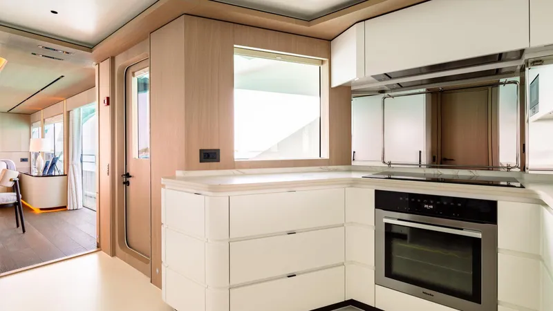 Midnight Saga Yacht Photos Pics Modern kitchen interior on 2023 Moonen 110 yacht, featuring sleek white cabinetry and stainless steel appliances.