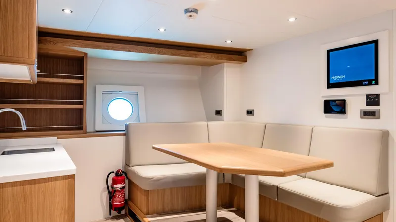 Midnight Saga Yacht Photos Pics Luxurious interior of 2023 Moonen 110 yacht with modern seating and porthole window.