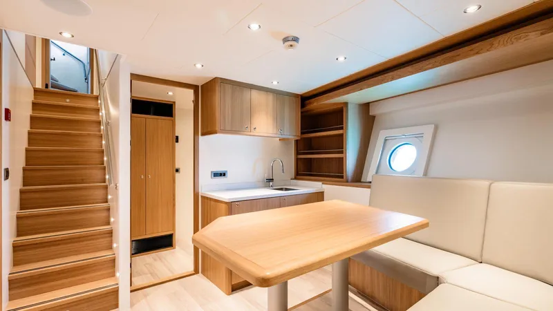 Midnight Saga Yacht Photos Pics Luxurious interior of 2023 Moonen 110 yacht with modern wood finishes and cozy seating area.