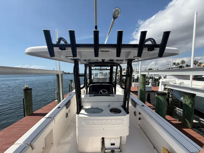 272-203 Brokerage Sebastian Yacht Photos Pics 2023 Robalo R272 Center Console boat docked, showcasing spacious deck and fishing rod holders.