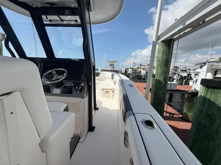 272-203 Brokerage Sebastian Yacht Photos Pics 2023 Robalo R272 Center Console boat docked at marina, showcasing helm and seating area.
