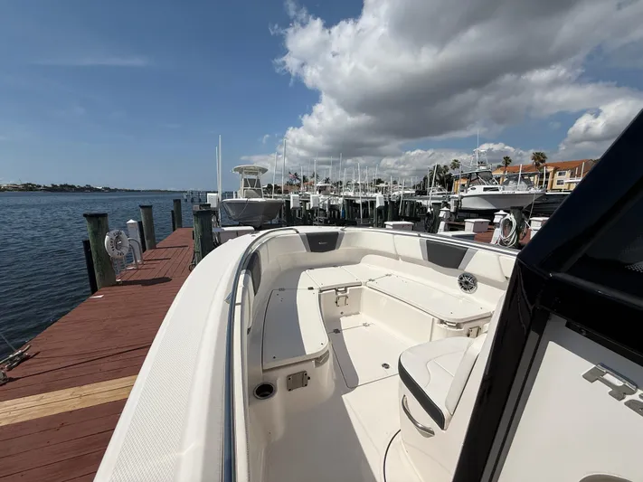 272-203 Brokerage Sebastian Yacht Photos Pics 2023 Robalo R272 Center Console boat docked at a marina under a partly cloudy sky.