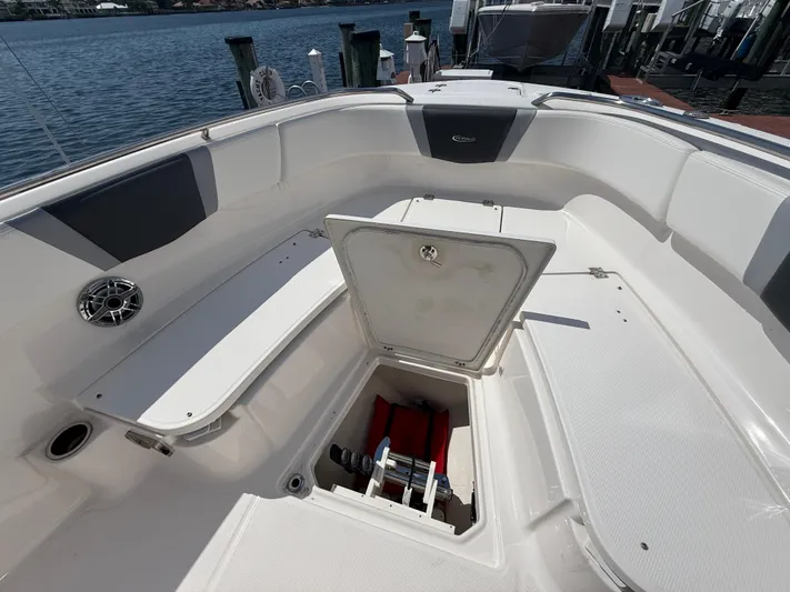 272-203 Brokerage Sebastian Yacht Photos Pics 2023 Robalo R272 Center Console boat with open storage compartment, docked by the water.