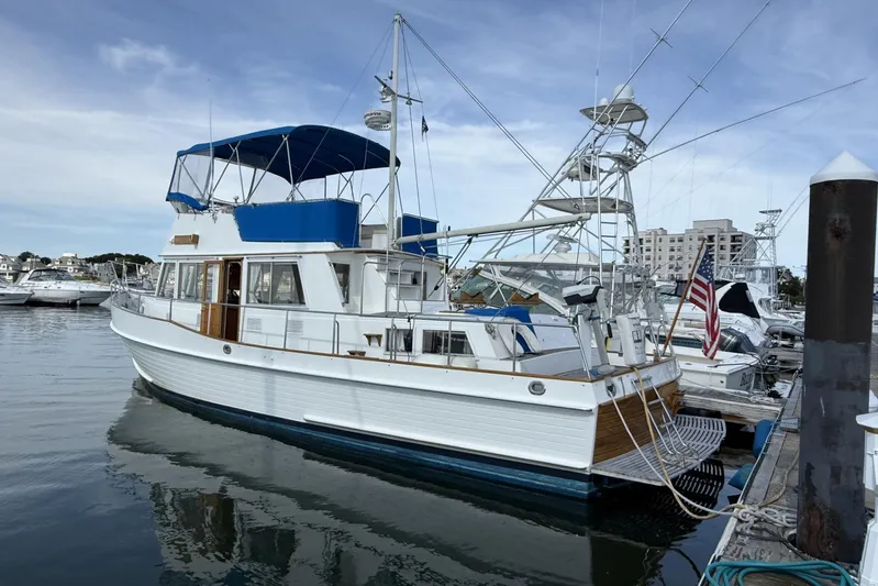  Yacht Photos Pics 1999 Grand Banks 42 Classic yacht docked in marina, featuring blue canopy and American flag.
