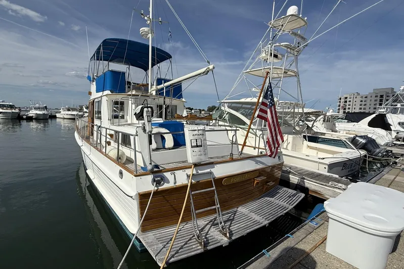  Yacht Photos Pics 1999 Grand Banks 42 Classic yacht docked at marina, featuring American flag and blue canopy.