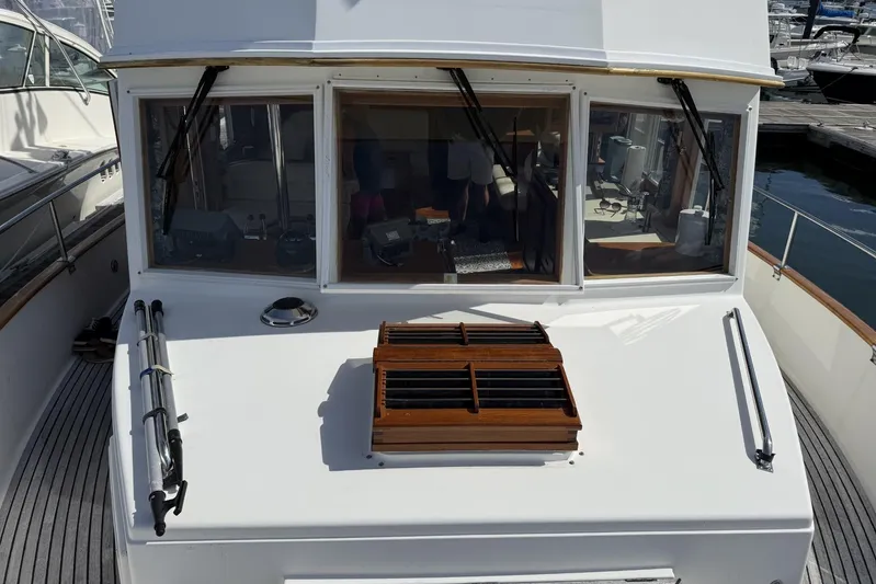  Yacht Photos Pics 1999 Grand Banks 42 Classic yacht with wooden deck and cabin windows at a marina.