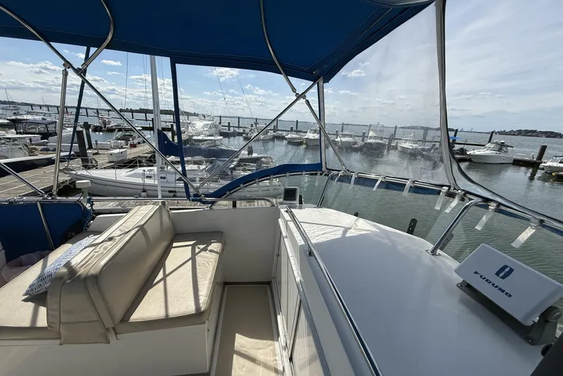  Yacht Photos Pics 1999 Grand Banks 42 Classic yacht with blue canopy, docked at marina.