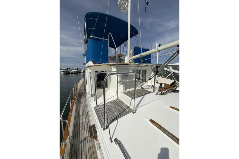  Yacht Photos Pics 1999 Grand Banks 42 Classic yacht with blue canopy, docked at marina.