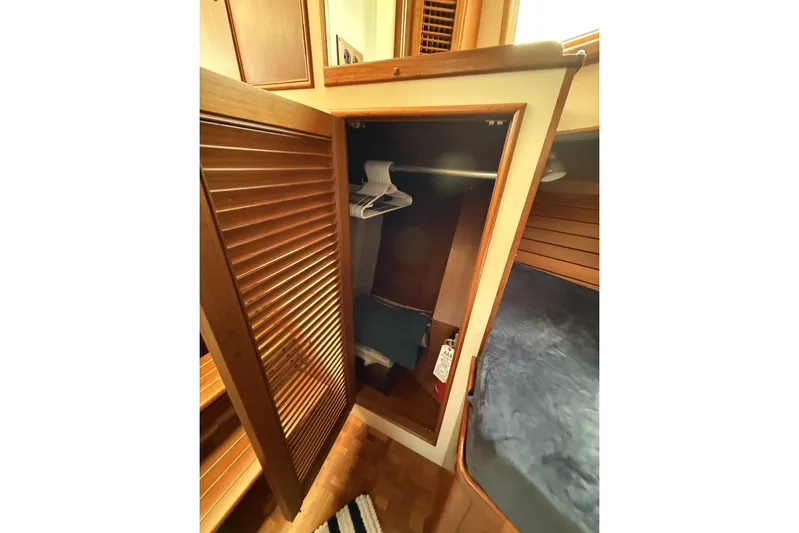 Yacht Photos Pics Wooden closet interior on 1999 Grand Banks 42 Classic yacht, featuring hangers and cozy cabin space.