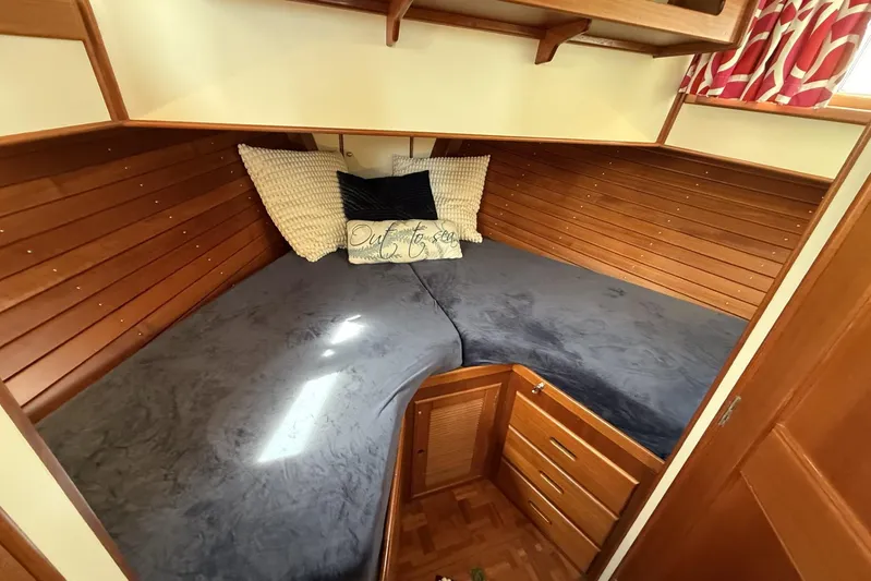  Yacht Photos Pics Cozy cabin interior of 1999 Grand Banks 42 Classic yacht with wooden paneling and bedding.