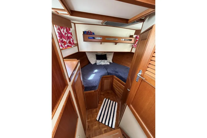  Yacht Photos Pics 1999 Grand Banks 42 Classic cabin interior with wood finish and cozy bedding.
