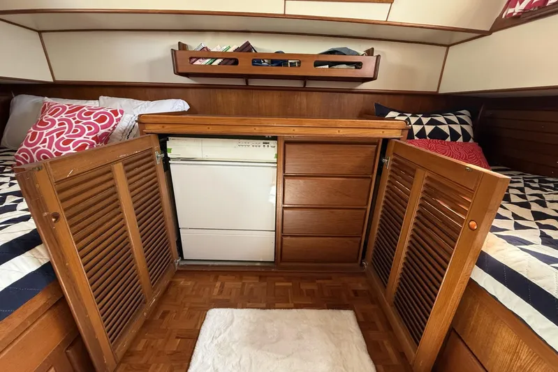  Yacht Photos Pics Interior of 1999 Grand Banks 42 Classic yacht with wooden cabinetry and cozy bedding.