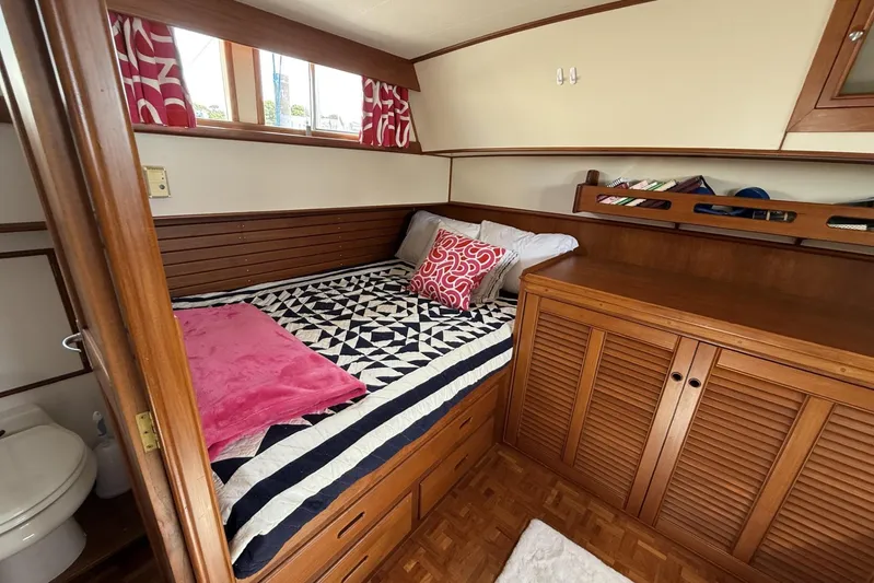  Yacht Photos Pics Cozy cabin interior of 1999 Grand Banks 42 Classic yacht with bed and wooden cabinetry.